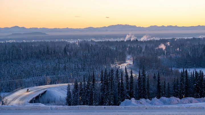 Snowy road through boreal forest at dusk