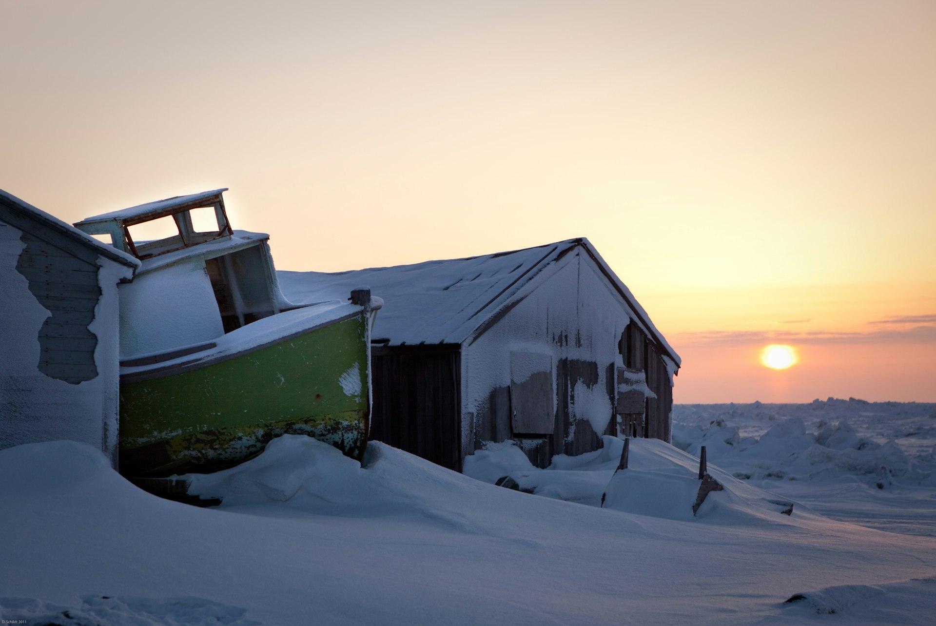 Homes in an Arctic community at sunset in winter