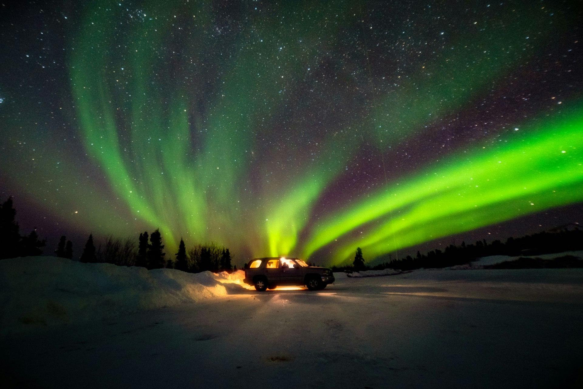 Northern lights over a snowy road at night