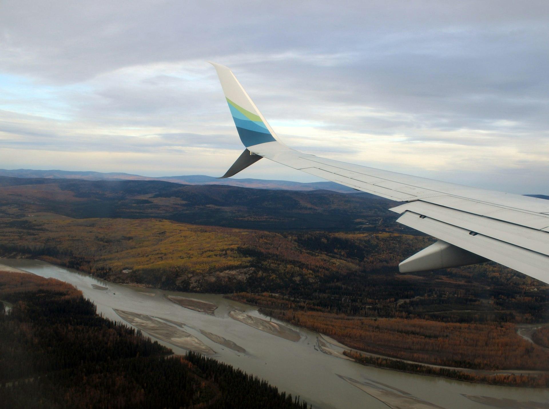 View from a small plane flying over a river and boreal forest