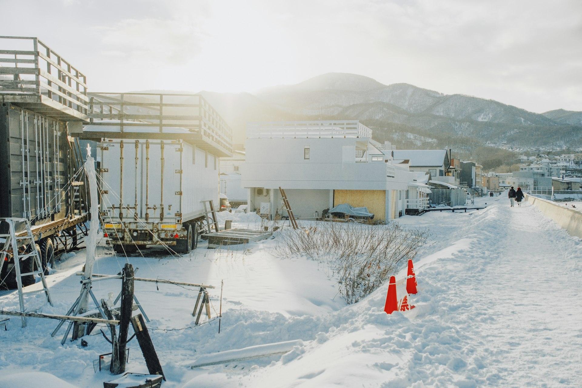 Snow-covered construction site with mountains in the distance