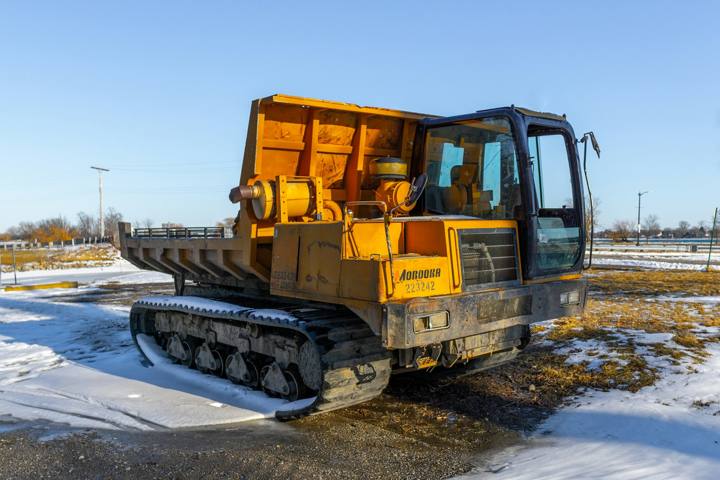 Yellow tracked vehicle parked in a snowy field